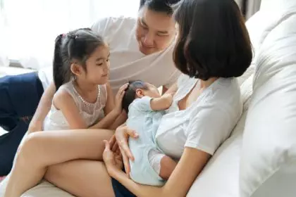 Happy family concept. Breast feeding newborn baby at home.