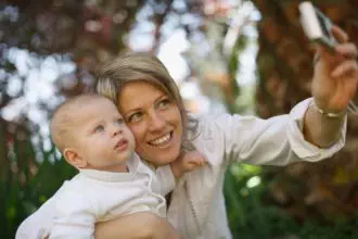 Mother taking picture with baby outdoors
